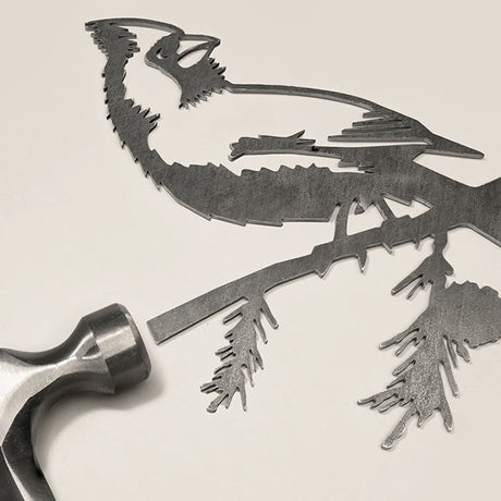 Metal Cardinal, Regular: A black and white sketch depicting a hammer hitting a bird silhouette, used to install this durable Corten Steel garden art piece.