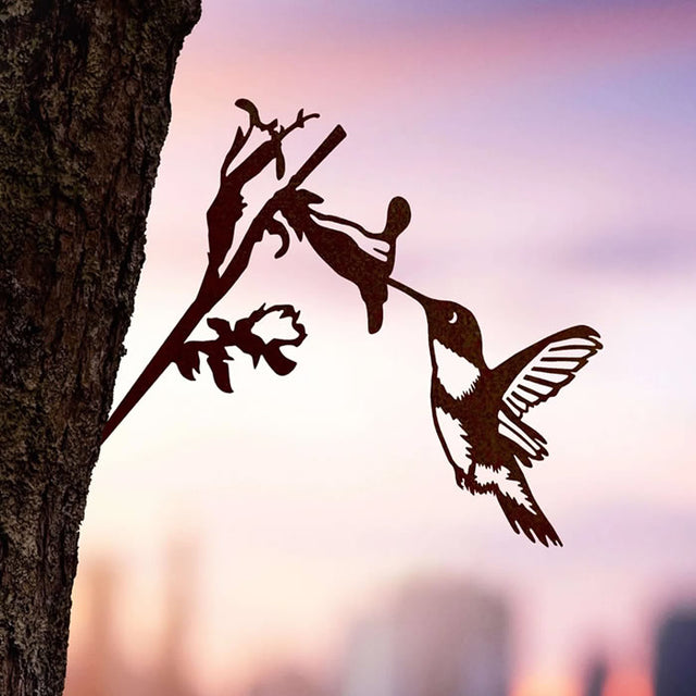 Metal Hummingbird silhouette in Corten Steel, perfectly capturing the Ruby-Throated species, perched on a tree branch, enhancing garden charm with weathering patina.