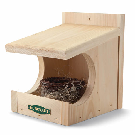 Duncraft Robin Nesting Shelter: A wooden bird house with an open nesting area containing a twig nest, ideal for robins and other birds.