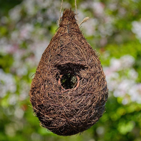 Hanging Roosting Nest Pocket For Small Birds, featuring a sturdy rattan frame with an overhang roof and brushwood finish, ideal for garden birds like robins.