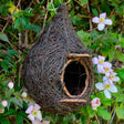 Hanging Roosting Nest Pocket for Small Birds: twig-constructed birdhouse with a rattan doorstep, nestled in tree foliage, ideal for garden bird shelter and protection.