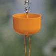 Close-up of the Nectar Protector Oriole Ant Moat, an orange plastic container designed to prevent ants from reaching feeders, featuring a large water reservoir.