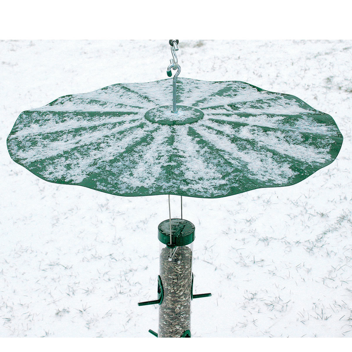 Extra Large Hanging Disk Squirrel Baffle, Green, covered in snow, features a metal hook and is designed to prevent squirrels from accessing bird feeders.