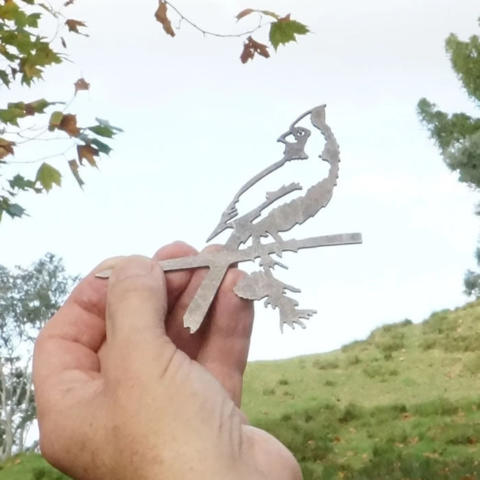 Hand holding Mini Metal Cardinal made of Corten Steel, precision-cut, showcasing a charming bird sculpture ideal for garden decoration.