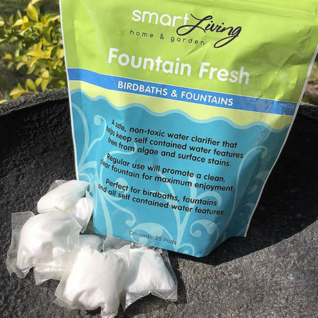 Fountain Fresh Natural Water Clarifier pods in a resealable bag, displayed alongside another bag and some white objects, designed to keep birdbaths clean and algae-free.