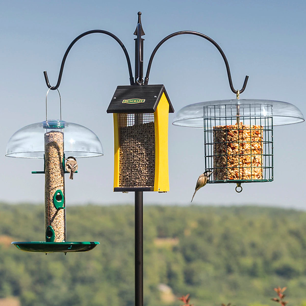 Squirrel-Proof Super Tall Quad Hanger with a yellow bird feeder on a pole, showcasing squirrel baffle protection and multiple arms for hanging feeders.
