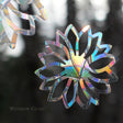 Close-up of Flower Window Gems, Set of 9, prismatic decals on a window designed to prevent bird strikes and add elegance.