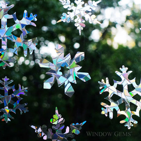 Snowflake Window Gems, Set of 9, displayed stuck on a window to prevent bird strikes with decorative snowflake designs enhancing the aesthetics.