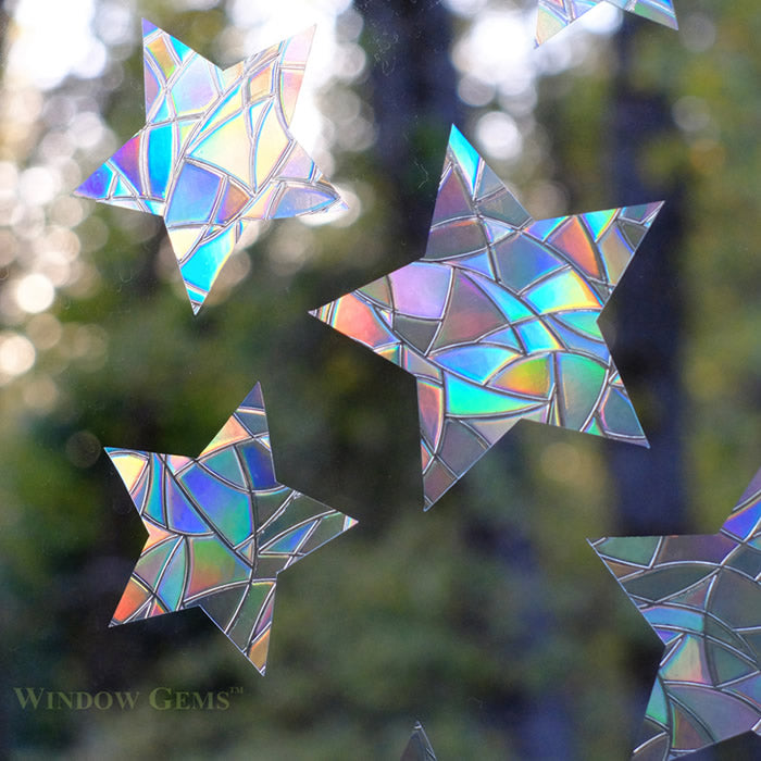 Star Window Gems, Set of 12, on a window. Prismatic star-shaped decals prevent bird strikes, adding elegance while easily adhering without residue.