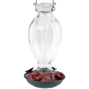 20 oz. Fluted Glass Hummingbird Feeder with a clear glass reservoir, colorful flower base, and metal hanger. Features four flower-shaped feeding ports.