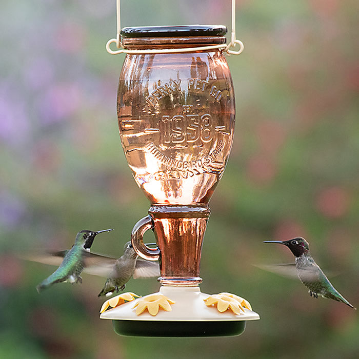 Sugar Maple Hummingbird Feeder with a glass reservoir, five petunia-shaped feeding ports, and a tan and black base, attracting hummingbirds while discouraging bees.