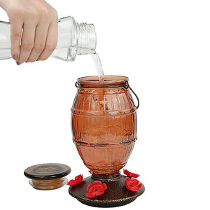 Prohibition Top-Fill Glass Hummingbird Feeder: A person fills a glass container with water, featuring five feeding ports and a barrel-inspired design for easy top-fill access.