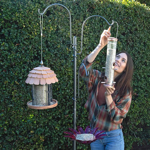 Woman holding the Yard Tree Bird Feeder Hanger, showcasing its customizable hooks and sturdy construction for outdoor use.