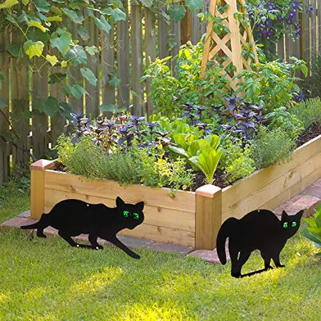 Garden Scare Cats with Reflective Eyes, Set of 4, strategically placed among plants to deter pests with a lifelike appearance, ensuring garden protection.