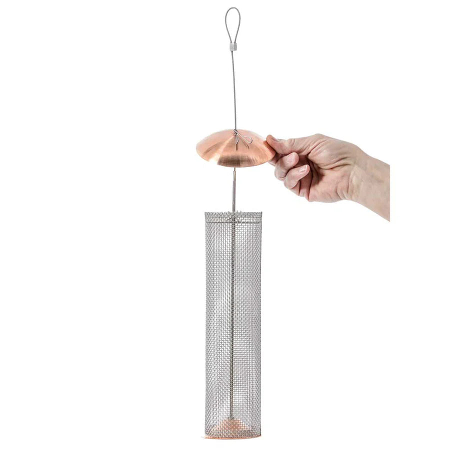 Hand holding Birds Choice Copper Nyjer® Mesh Feeder with stainless steel screen, copper top and bottom, designed for easy filling and cleaning, includes hanging cable.